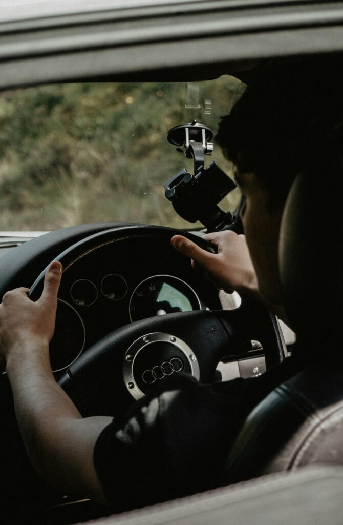 Interior view focusing on a man steering an Audi car, showcasing a modern luxury vehicle design.